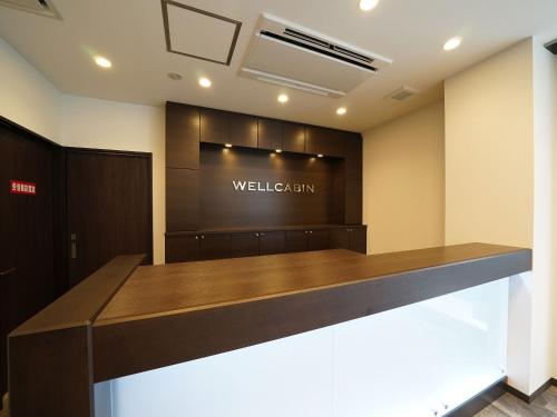 a lobby with a welcome sign on the wall at WELLCABIN TENJIN - Male Only in Fukuoka