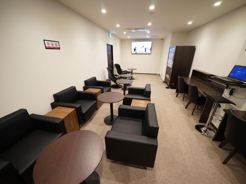 a waiting room with couches and a piano at WELLCABIN TENJIN - Male Only in Fukuoka