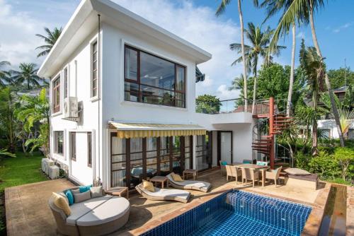 a villa with a swimming pool and a house at Lotus Samui Luxury Beach Villas in Mae Nam