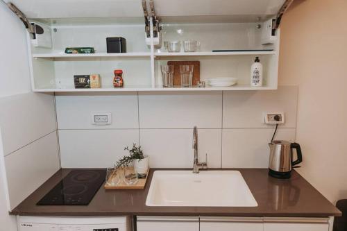 a small kitchen with a sink and a stove at In the Middle of everything in Haifa