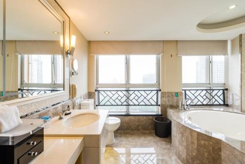 uma casa de banho com uma banheira, um WC e um lavatório. em S&N Hotel Jiujiang em Jiujiang