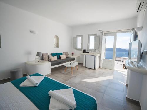 un soggiorno bianco con un divano e un tavolo di Vitsentzos Suites a Imerovigli