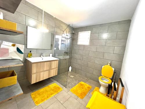 a bathroom with a yellow toilet and a sink at Nour Lumière d’Etoile in Saint-Pierre