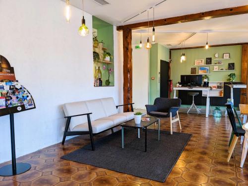 a living room with a couch and a table at Hôtel PB - Paris-Barcelone in Perpignan