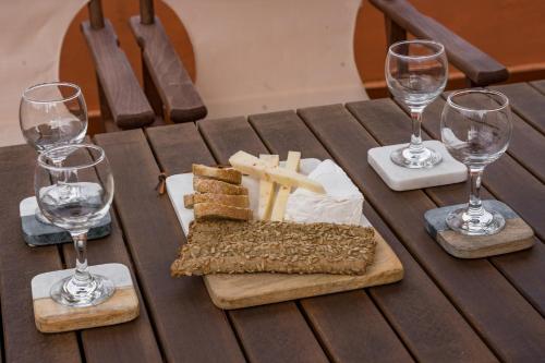 a wooden table with a plate of cheese and wine glasses at Sant'Agata in Lixouri