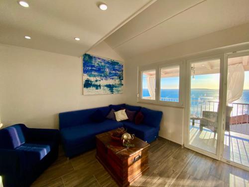 a living room with a blue couch and a table at Tanis Ocean Loft in Martinšćica