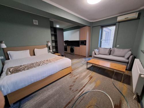 1 dormitorio con 1 cama grande y 1 sofá en The Corporate Hotel, en Ulán Bator