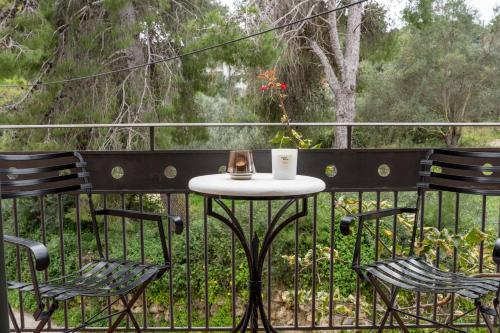 a table with a tea kettle and two chairs on a balcony at Sant'Agata in Lixouri