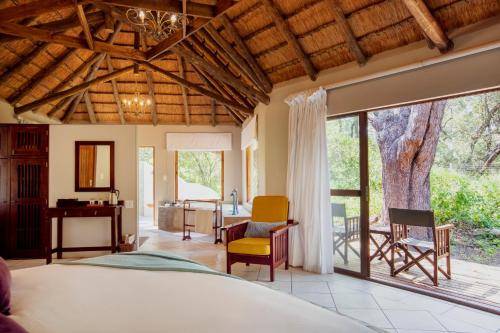 a bedroom with a bed and a large window at Thamo Telele in Maun