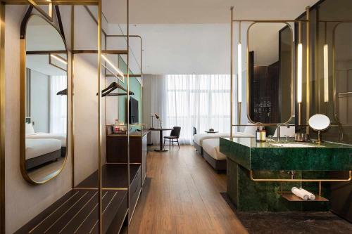 a hotel room with a bathroom with a sink and a mirror at S&N Yiting Hotel Taizhou in Taizhou