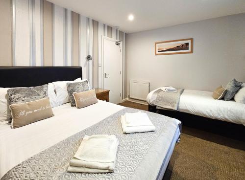 a hotel room with two beds with towels on them at Pearl Suite in Blackpool