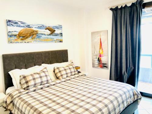 アプリーリア・マリッティマにあるVilla Aprilia with THERMAL SPA POOLのベッドルーム1室(チェック入りの毛布付きのベッド1台付)