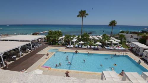 a large swimming pool with the ocean in the background at Silver Sands Beach Hotel in Protaras