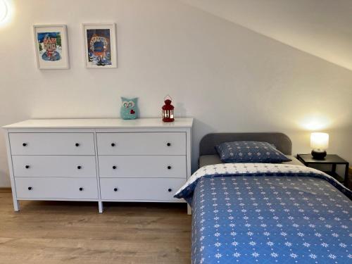 a bedroom with a bed and a white dresser at BERUŠKA Apartmán in Oščadnica