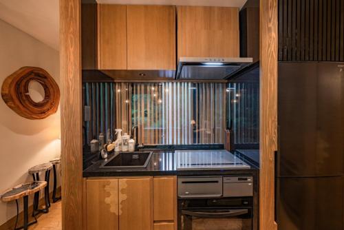 a kitchen with a stove and a refrigerator at Treeful Treehouse Sustainable Resort in Nago