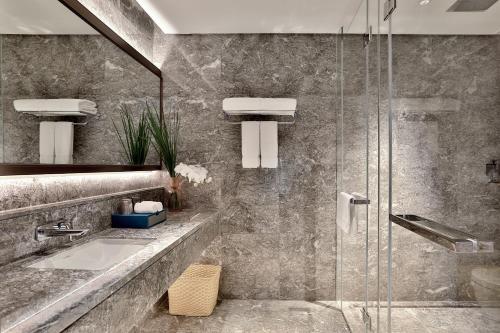 a bathroom with a glass shower and a sink at Yiwu Yandoo Yayue Hotel in Yiwu