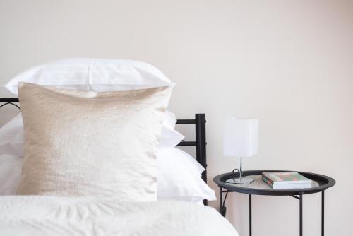 a bed with a white pillow and a side table at Prague - Karlin Apartments in Prague