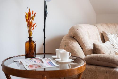 a coffee table with two cups and a vase at Prague - Karlin Apartments in Prague