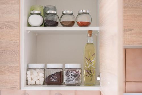 a shelf with jars and a bottle of wine at Prague - Karlin Apartments in Prague