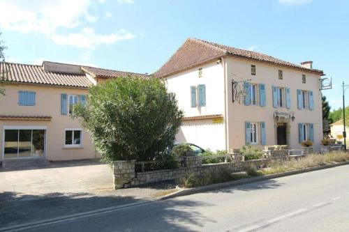 une maison blanche avec une voiture garée devant elle dans l'établissement SAS Relais de la tour, à Termes-dʼArmagnac