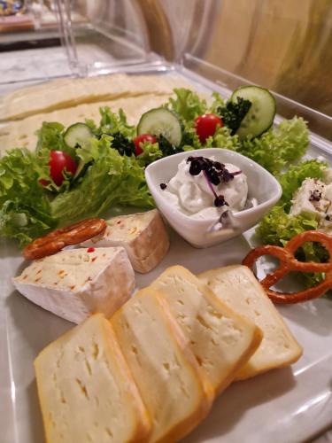 a plate of food with cheese and a salad at Landgasthof Zehner in Drosendorf