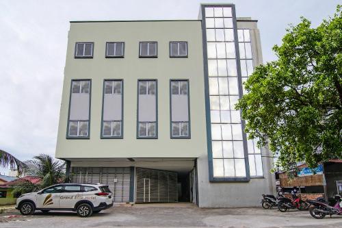 a white building with a car parked in front of it at SUPER OYO 92300 Koala House in Pekanbaru