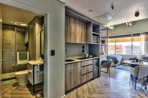 a kitchen and living room with a dining room at WINK Aparthotel One Thibault in Cape Town