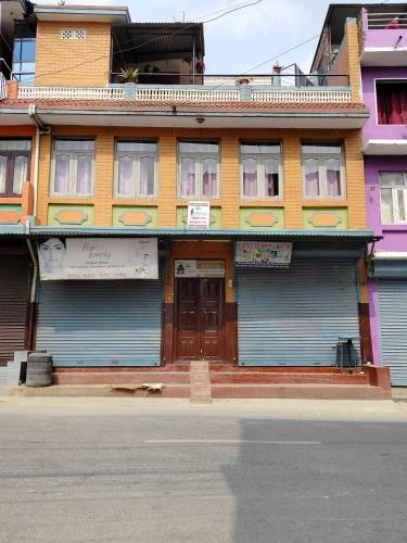 a building with blue garage doors on a street at COMMUNITY HOLIDAY INN in Panauti