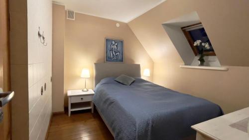 a small bedroom with a blue bed and a table at Manni Homestay in Kuressaare
