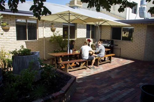 a man and a woman sitting on a bench in front of a house at The Shiralee in Perth