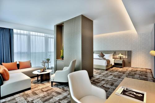 uma suite de hotel com uma cama e uma sala de estar em Yiwu Yandoo Yayue Hotel em Yiwu