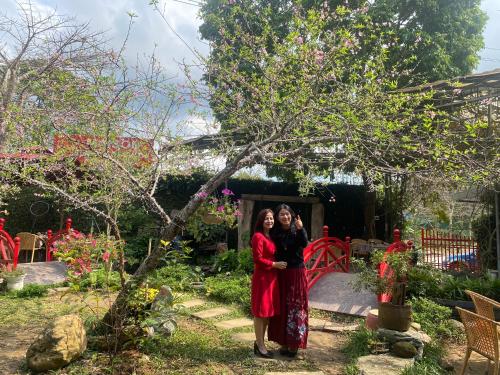 ハザンにあるMaison Teahouse homestayの二人の女が隣り合って庭に立っている