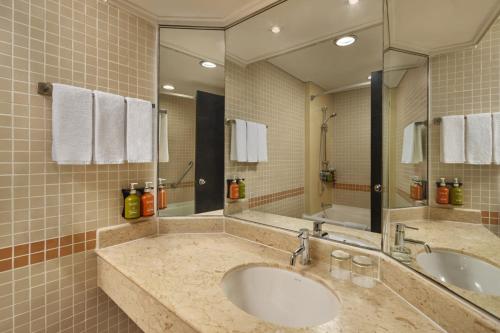 a bathroom with two sinks and a large mirror at Holiday Inn Singapore Atrium by IHG in Singapore