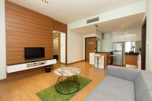 een woonkamer met een bank en een televisie bij Dua Sentral by Cobnb in Kuala Lumpur