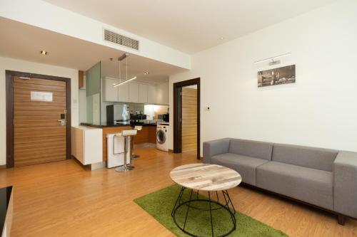 吉隆坡的住宿－Dua Sentral by Cobnb，带沙发和凳子的客厅以及厨房。