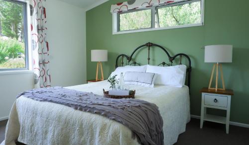 a bedroom with a bed and two windows at Vines on Bannockburn in Cromwell