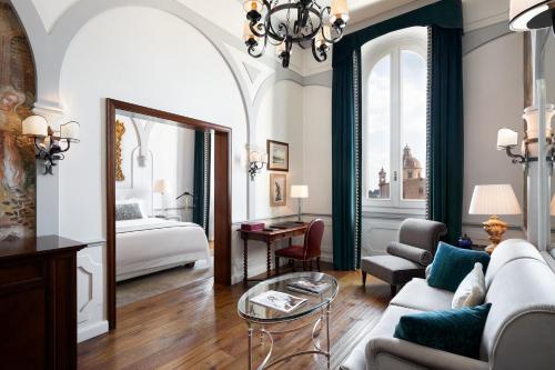 uma sala de estar com um sofá e uma cama em The St. Regis Florence em Florença