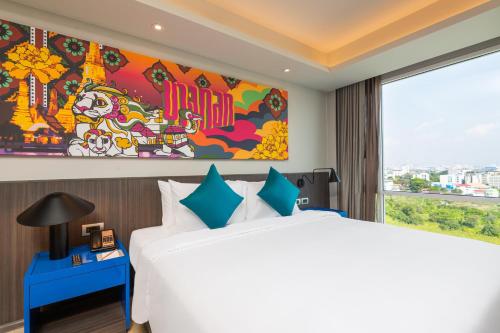 a bedroom with a large bed and a large window at Maitria Hotel Rama 9 Bangkok - A Chatrium Collection in Bangkok