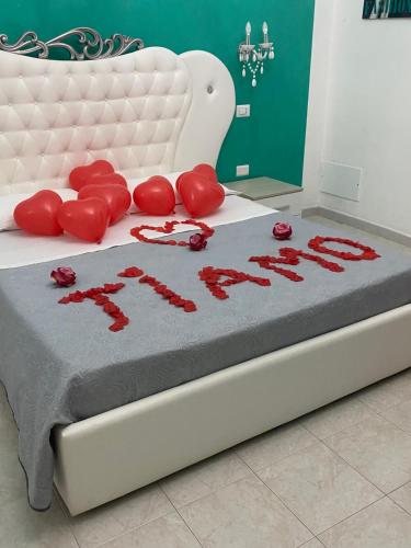 a bed with red writing on it with roses on it at Affitta Camere Romy in Tropea