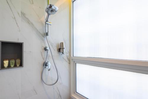a shower in a bathroom with a window at Maitria Hotel Rama 9 Bangkok - A Chatrium Collection in Bangkok