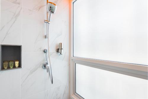 a shower in a bathroom with a window at Maitria Hotel Rama 9 Bangkok - A Chatrium Collection in Bangkok