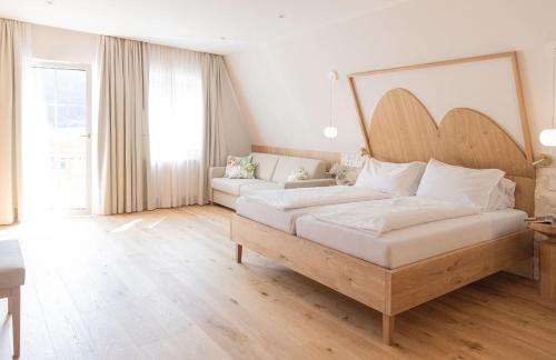 a large bedroom with a bed and a couch at Hotel Weissenstein in Sankt Michael im Lungau