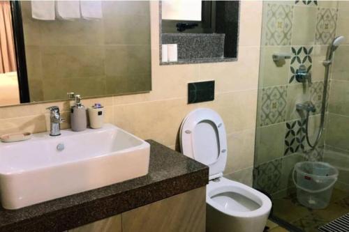 y baño con lavabo, aseo y espejo. en 03-JenVin Luxury Homes - Garden view 2bed Apartment North Goa, en Old Goa