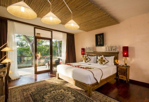 een slaapkamer met een groot bed en een groot raam bij Jungle Retreat by Kupu Kupu Barong in Ubud