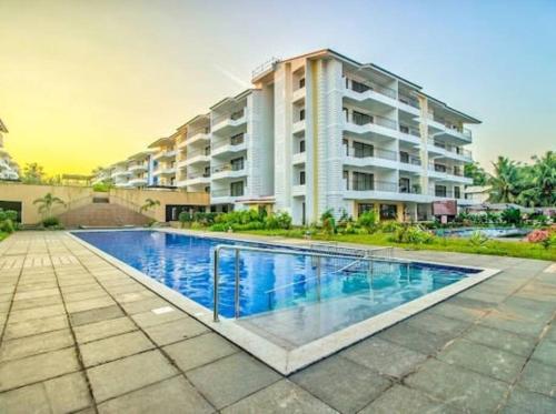 una piscina frente a un edificio de apartamentos en 03-JenVin Luxury Homes - Garden view 2bed Apartment North Goa en Old Goa