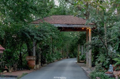 a walkway in a garden with a pergola at Muaan Resort in Suphan Buri