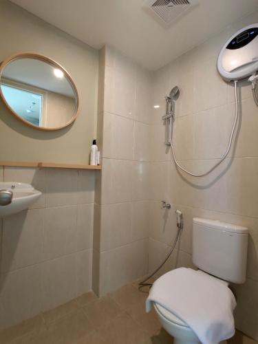 a bathroom with a shower and a toilet and a mirror at Hotel Osaka PIK2 in Tangerang