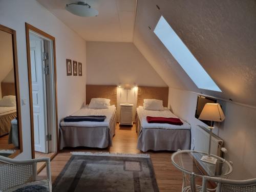 a attic room with two beds and a window at Linda Gård Apartments in Yngsjö