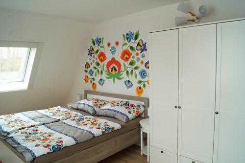 a bedroom with a bed with a floral mural on the wall at Apartmán Pod Kaštany in Bystřice nad Pernštejnem