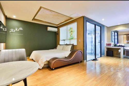 Time Hotel في Yangsan: غرفة نوم فيها سرير وطاولة فيها